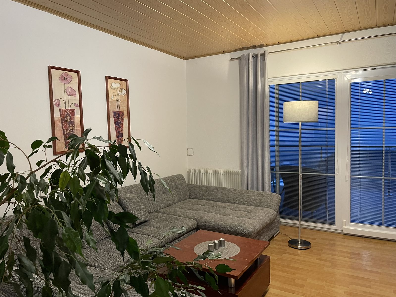 Obývací pokoj apartmánu s pohovkou a velkými okny